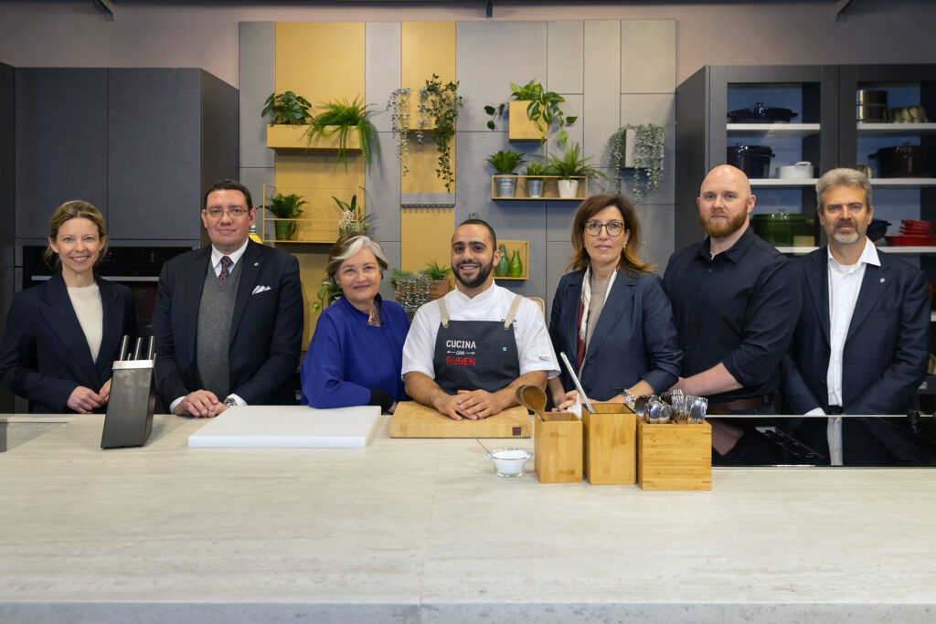 Event speakers with chef stand in kitchen